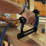 Worker operating a power tool on wood